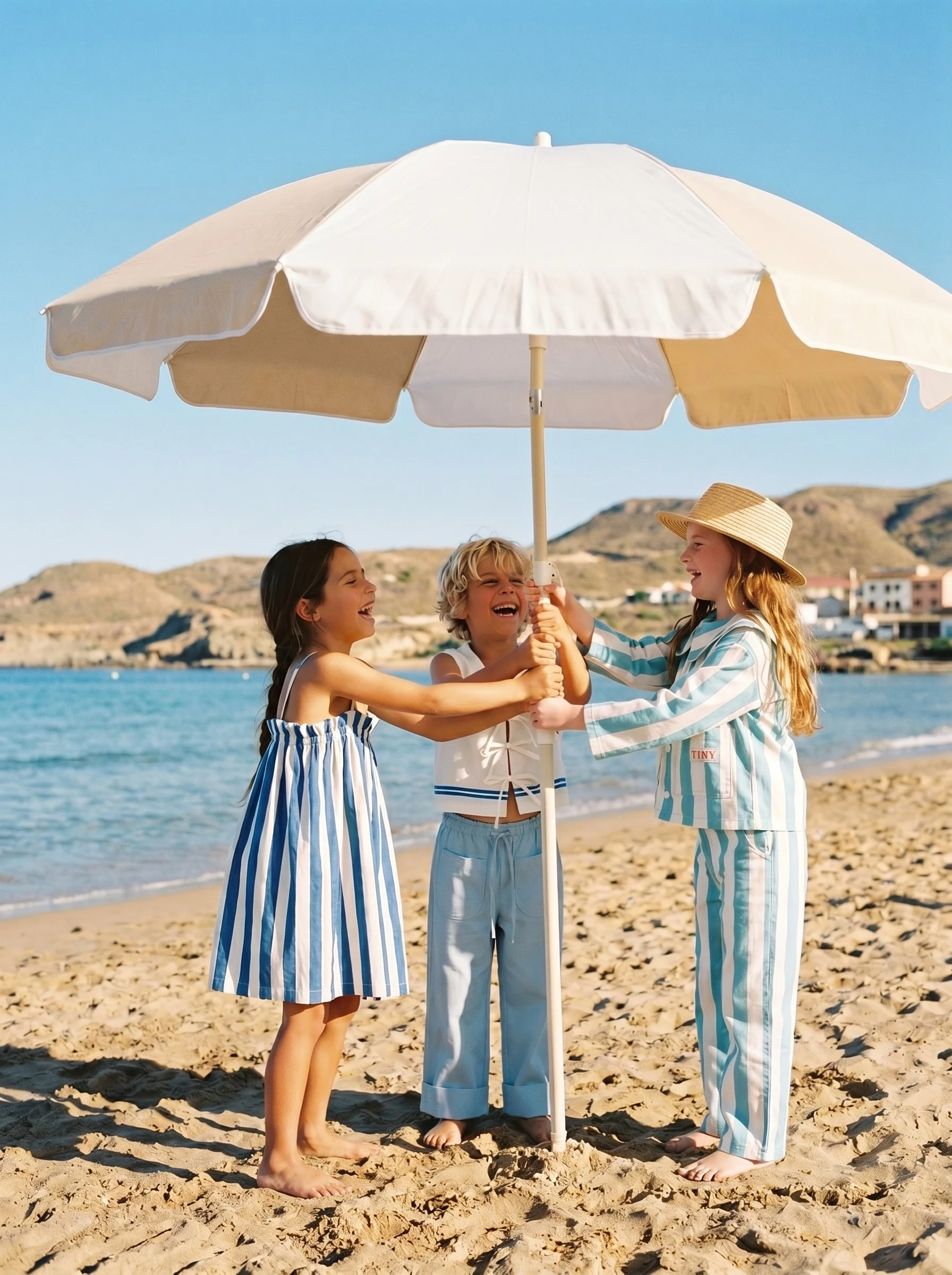 Cream beach umbrella against a clear blue sky in a children's lifestyle campaign