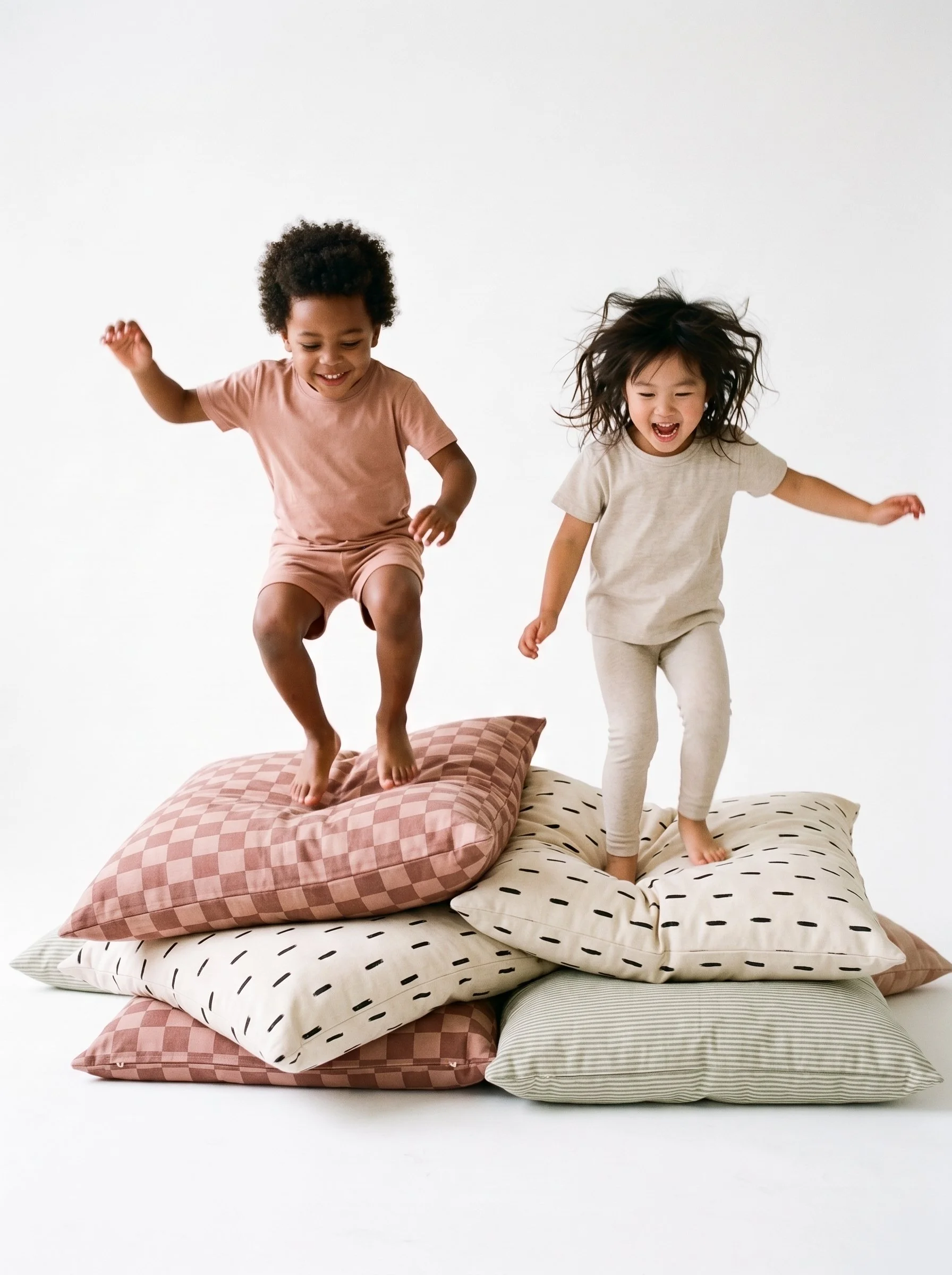Children jumping on soft play cushions in a bright lifestyle scene