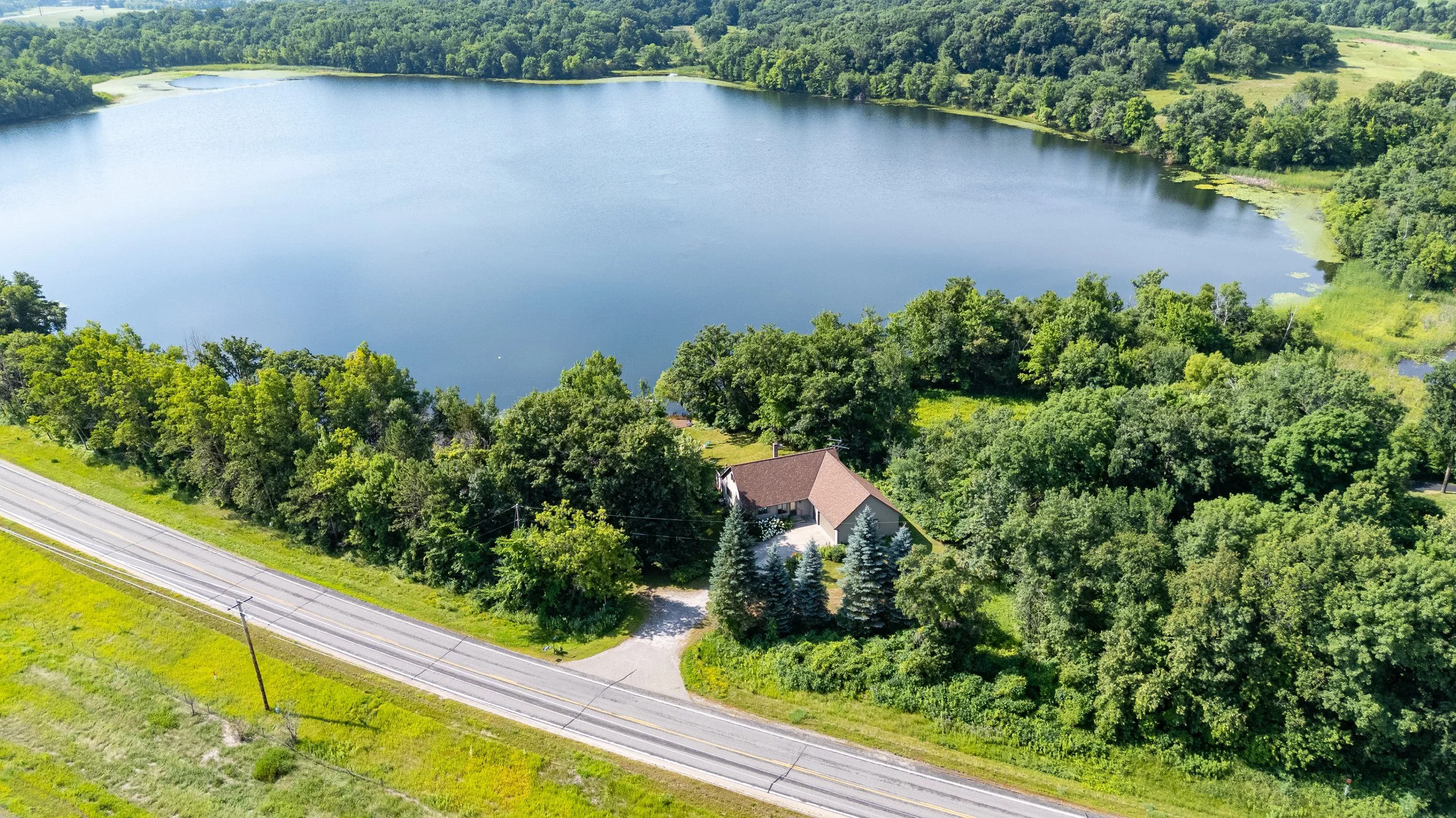 Aerial view of a lakeside property with a pool
