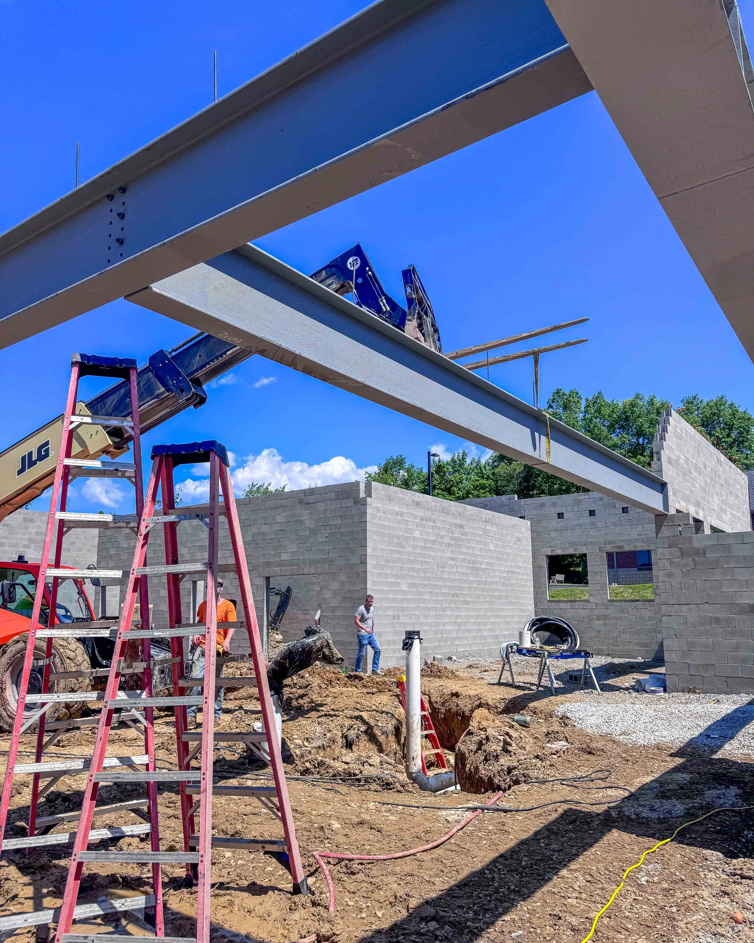 Large steel beam being set with a lift between concrete block walls at Common Ground Kitchen & Taps in McMurray, PA.