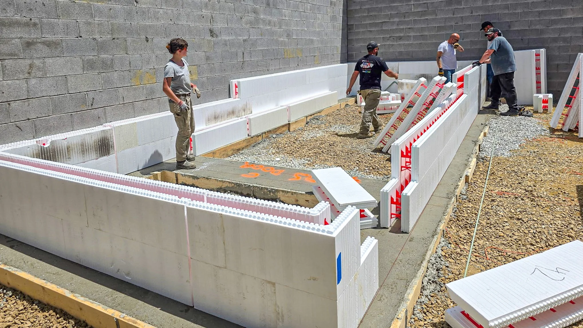 Workers installing white insulated concrete forms inside the future Common Ground Kitchen & Taps restaurant in McMurray, PA.