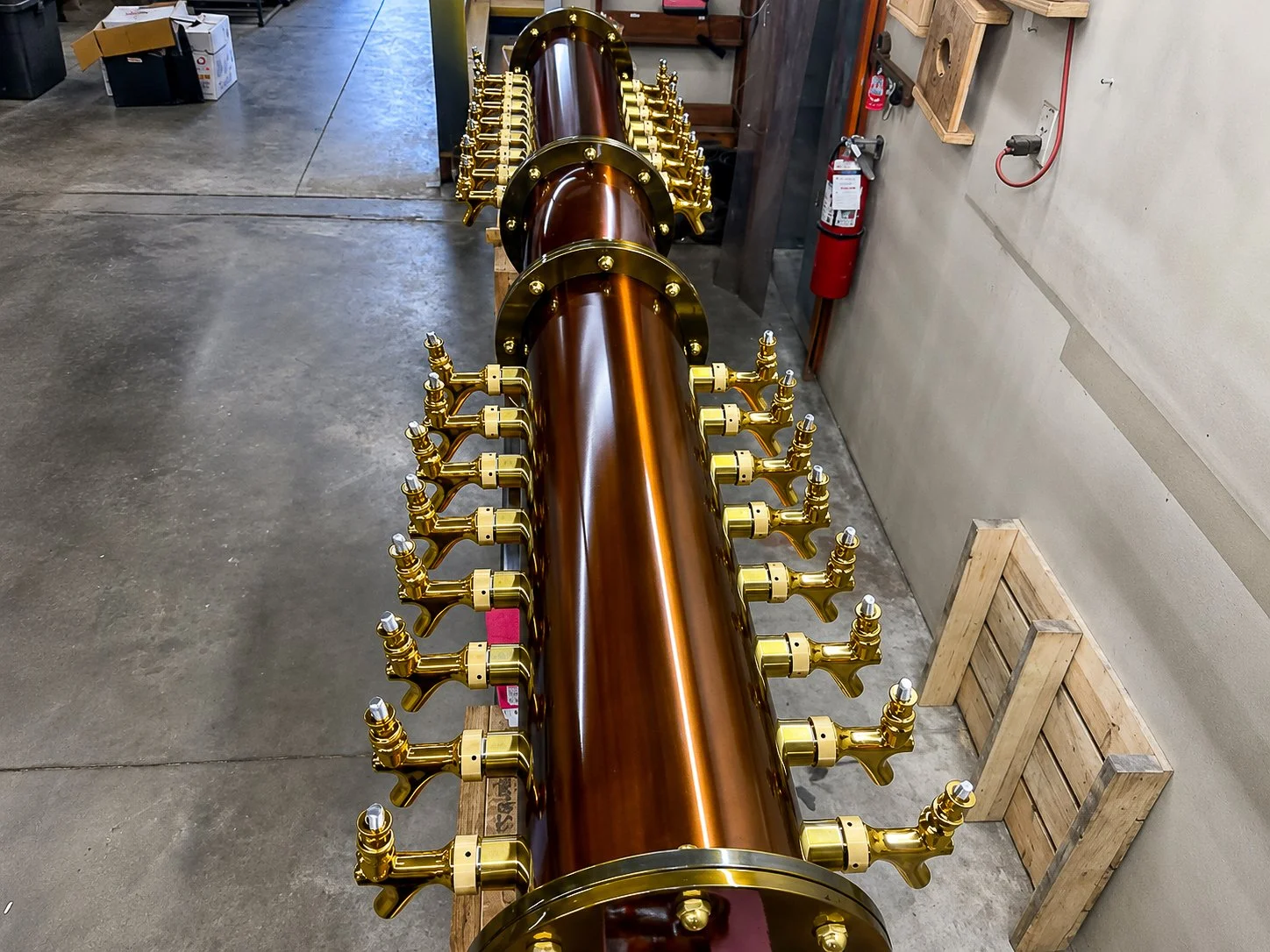 Completed custom copper and brass draft tower for Common Ground Kitchen & Taps in McMurray, PA, seen down its length with both rows of brass taps.
