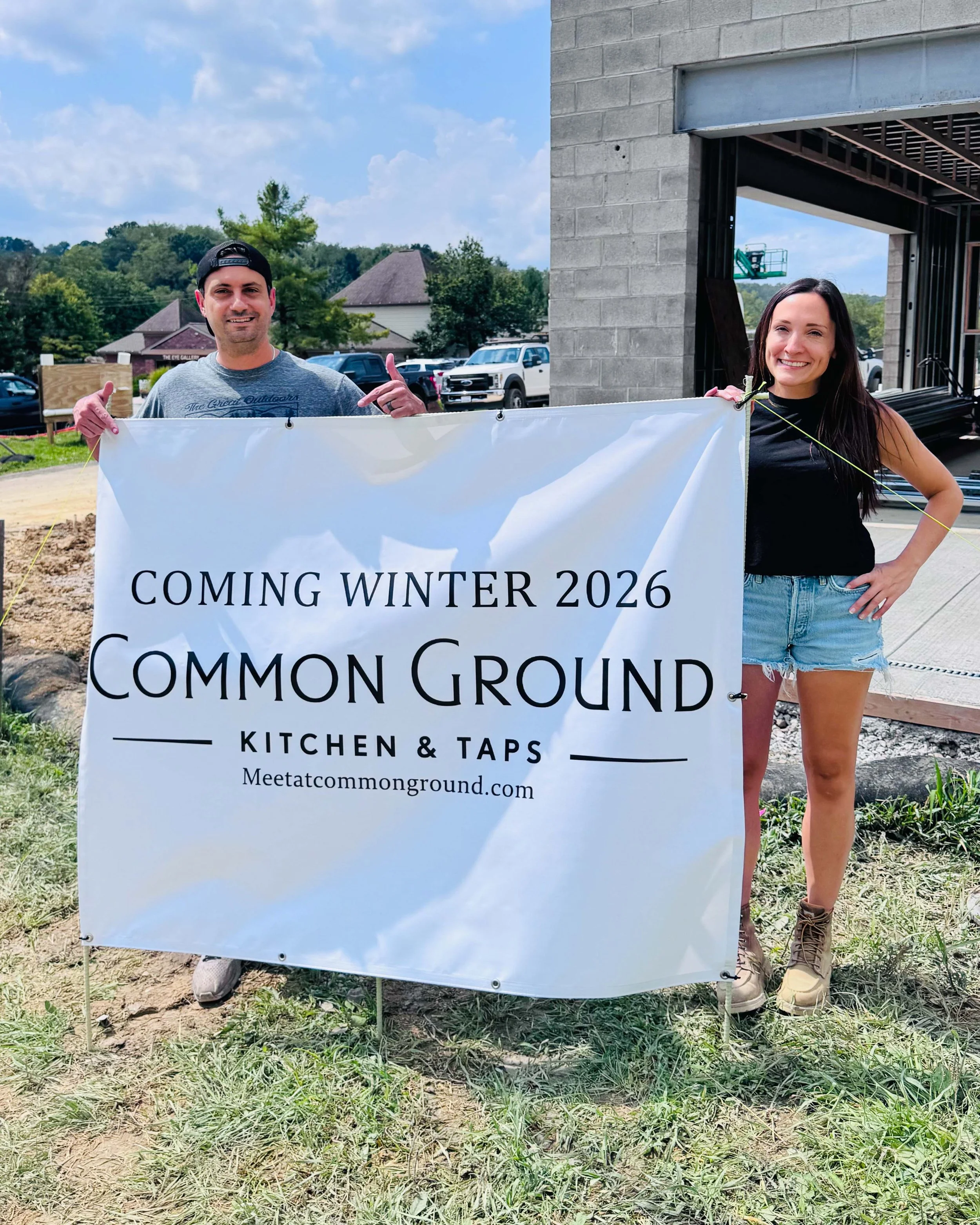 Brian Vetere and Laura Vetere holding a Coming Winter 2026 banner for Common Ground Kitchen and Taps outside their restaurant under construction at 615 East McMurray Road in McMurray, PA.