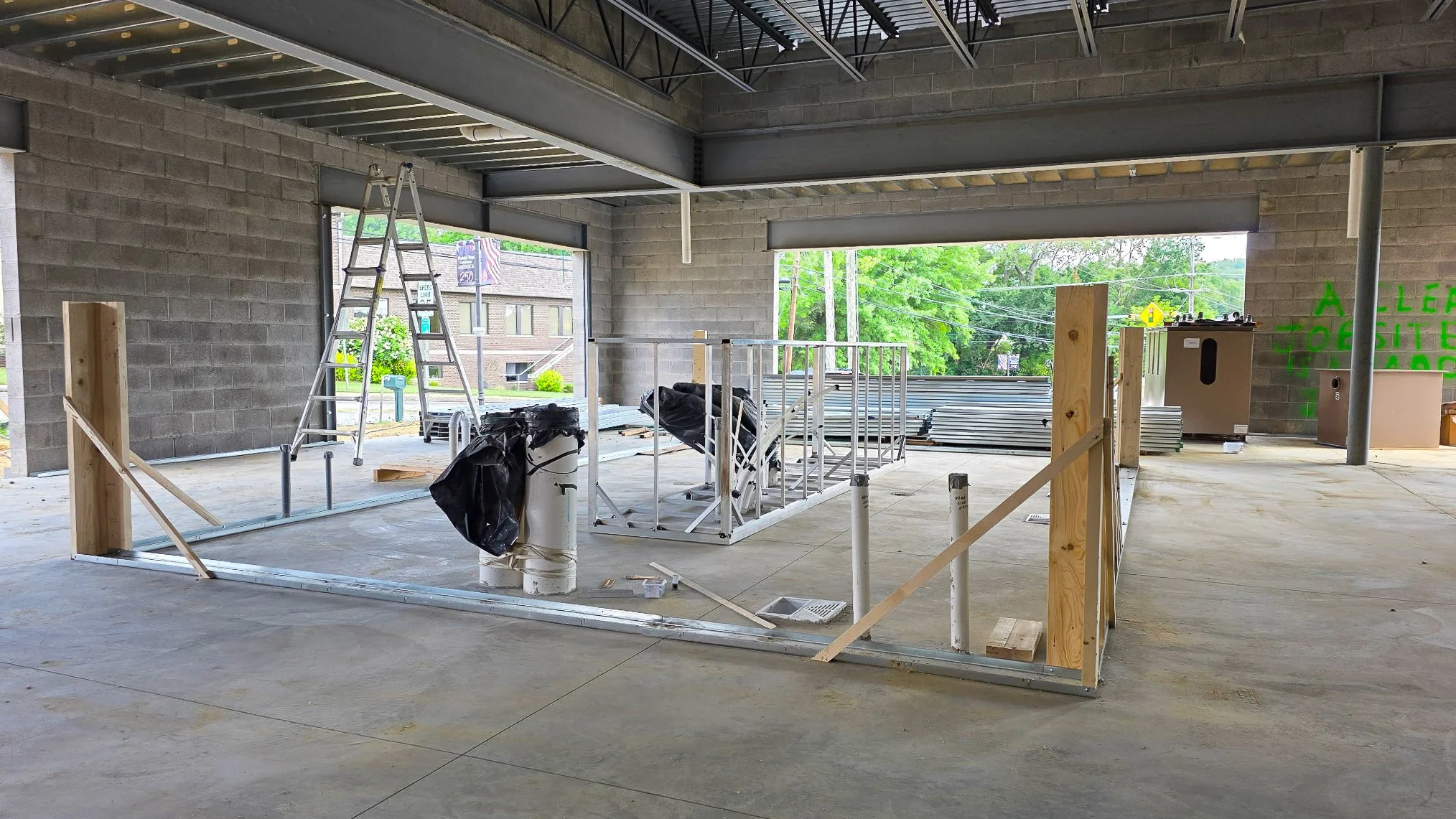Metal wall track laid out on the poured concrete slab marking interior room lines at the Common Ground Kitchen and Taps restaurant construction site in McMurray, PA.