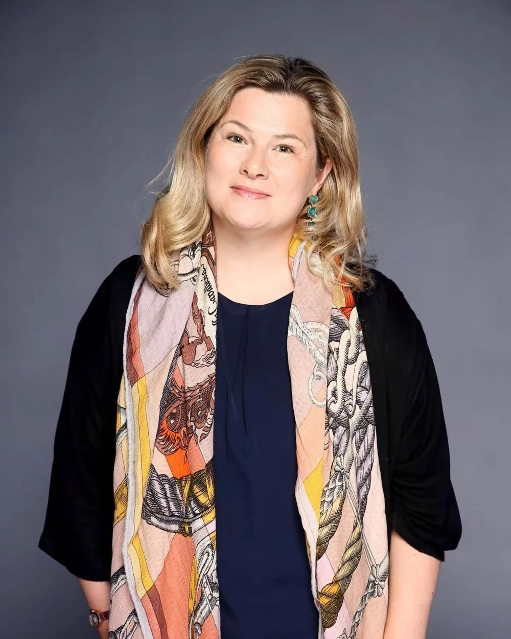 Portrait of Janice Stewart-Yates smiling, wearing a patterned silk scarf