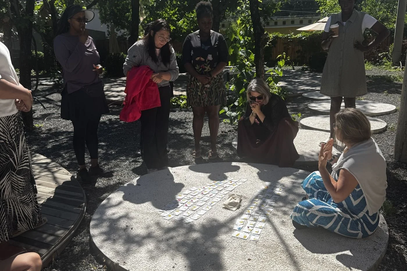 Retreat participants gathered in a sunlit garden circle at The Weight of Elsewhere