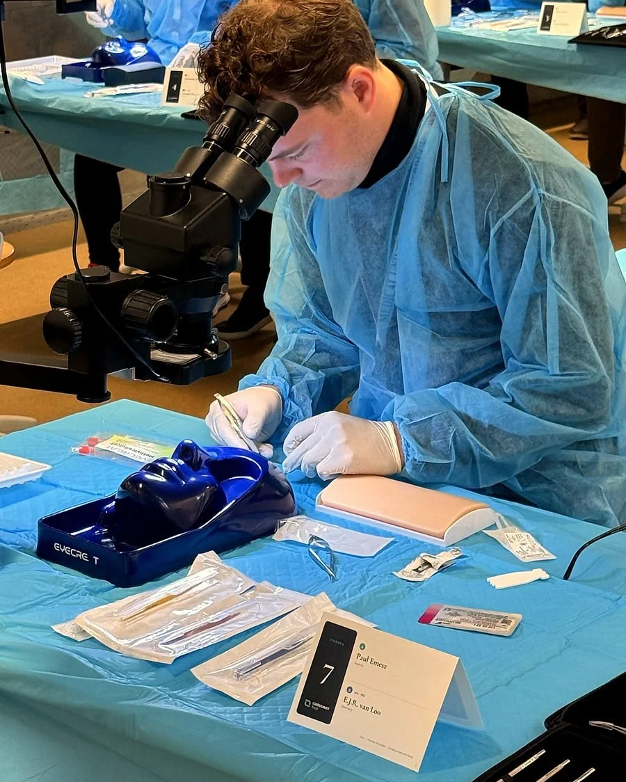 Participant practising corneal suturing under the microscope on an eyecre.at training eye