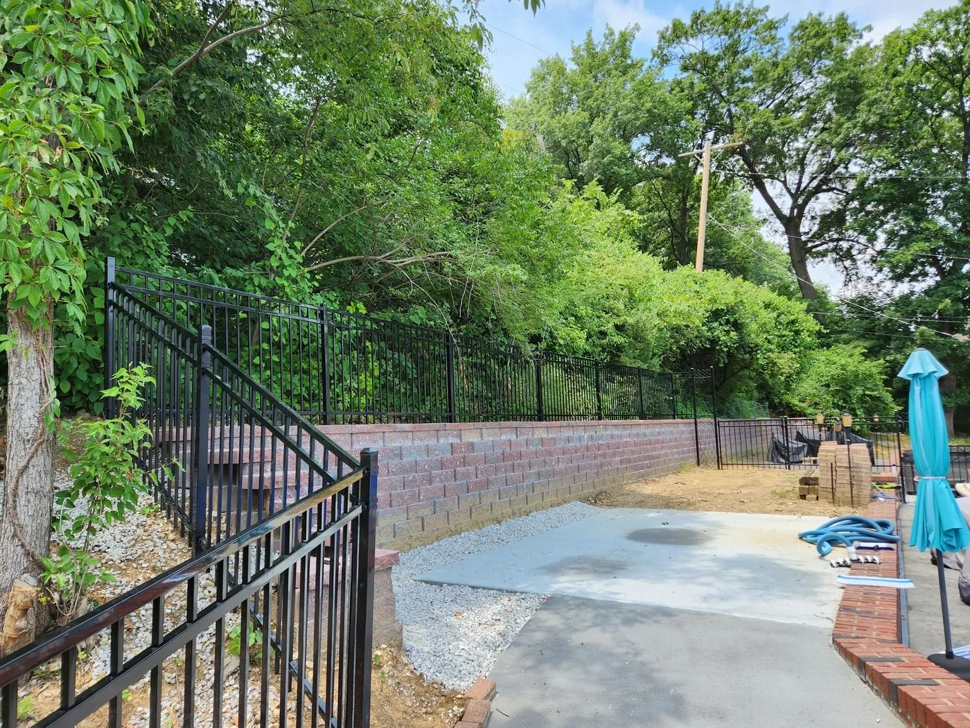 Pool enclosure retaining wall