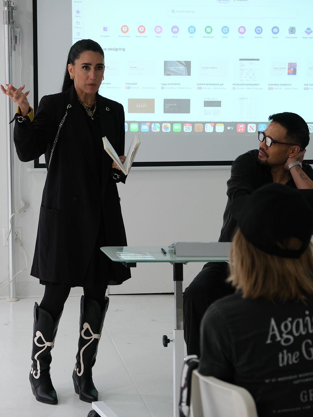 Alyce Barrick speaking to the cohort with a notebook in hand while Jeff listens