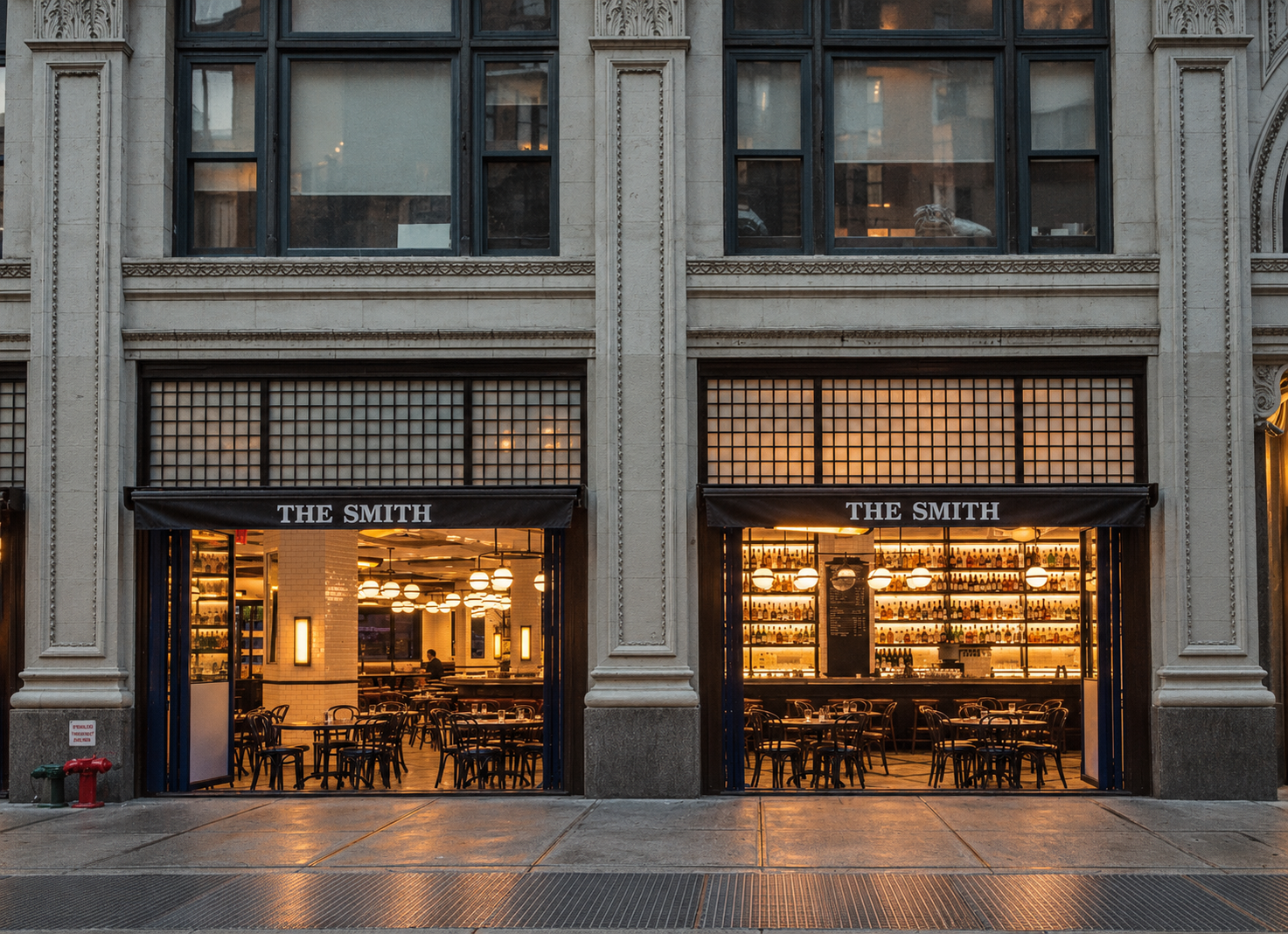 The Smith in NoMad at dusk, its two glass fronts lit warm from inside