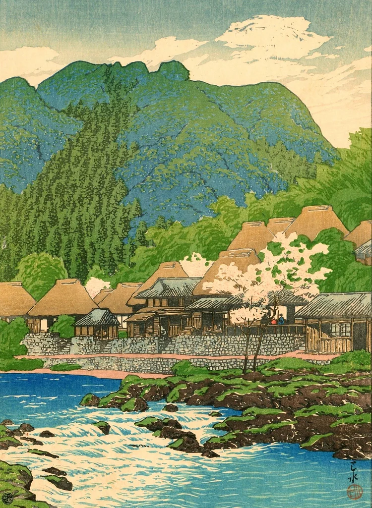 Traditional wooden buildings and flowering trees stand beside a blue rocky stream below green mountains.
