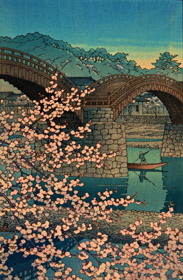 Canvas reprint of Spring Evening at Kintai Bridge by Kawase Hasui: pink cherry blossoms frame arched wooden bridge spans, stone piers and a solitary boatman on blue-green water at dusk.