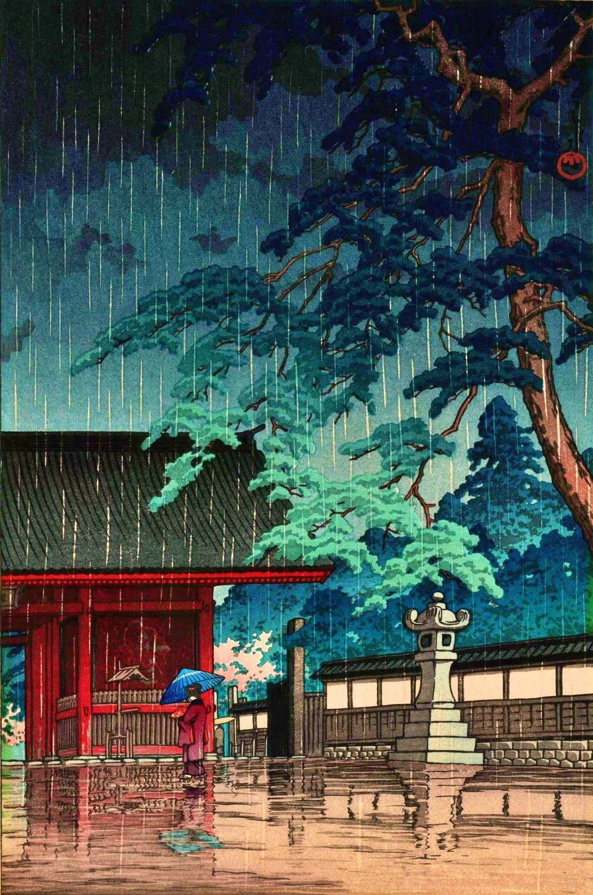 Spring Rain at Gokoku Temple by Kawase Hasui: a vermilion gate, a visitor beneath a blue umbrella, a stone lantern, spreading pine branches, and fine rain reflected on wet ground.
