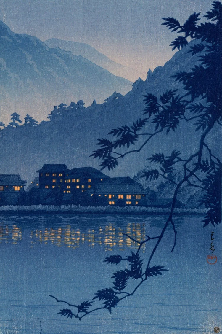 Warmly lit inns and golden reflections glow against still blue water, layered mountain silhouettes and a dark arching branch.