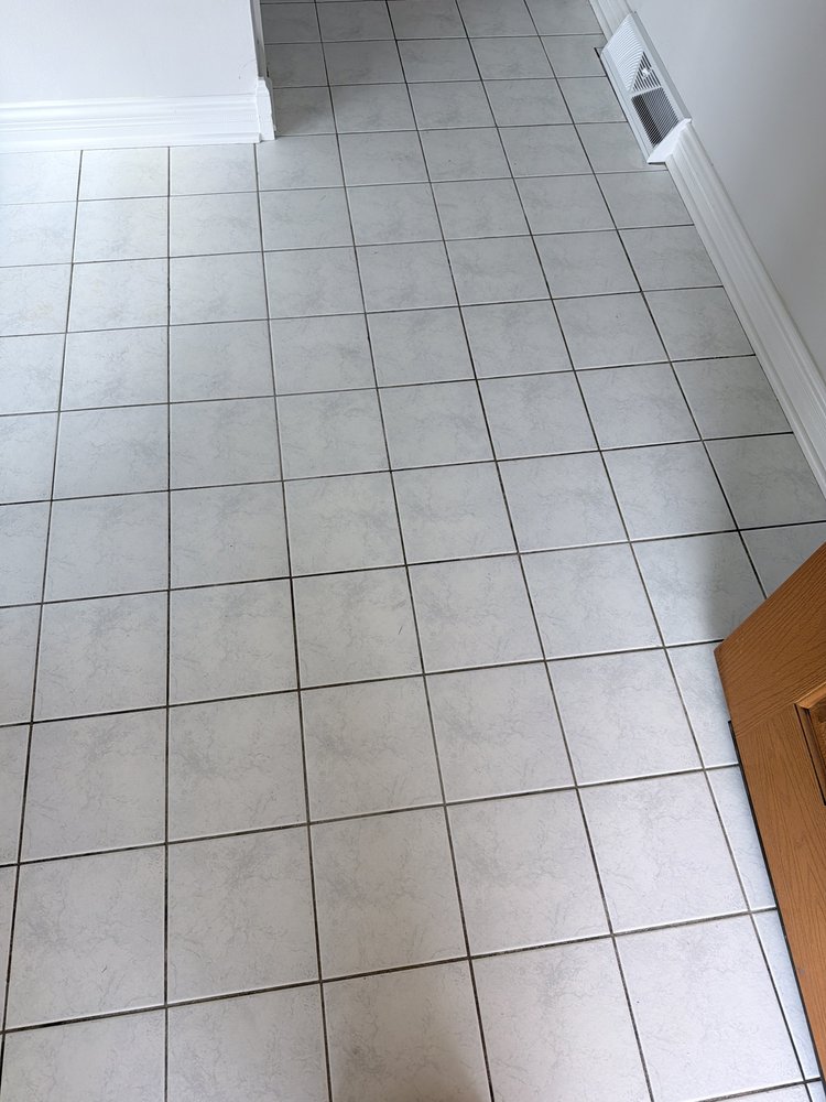 Light tile hallway before cleaning and colorsealing, showing dark uneven grout lines