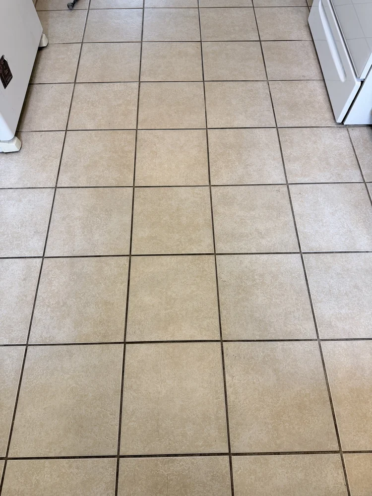 Beige kitchen tile floor before cleaning and colorsealing, showing dark contrasting grout