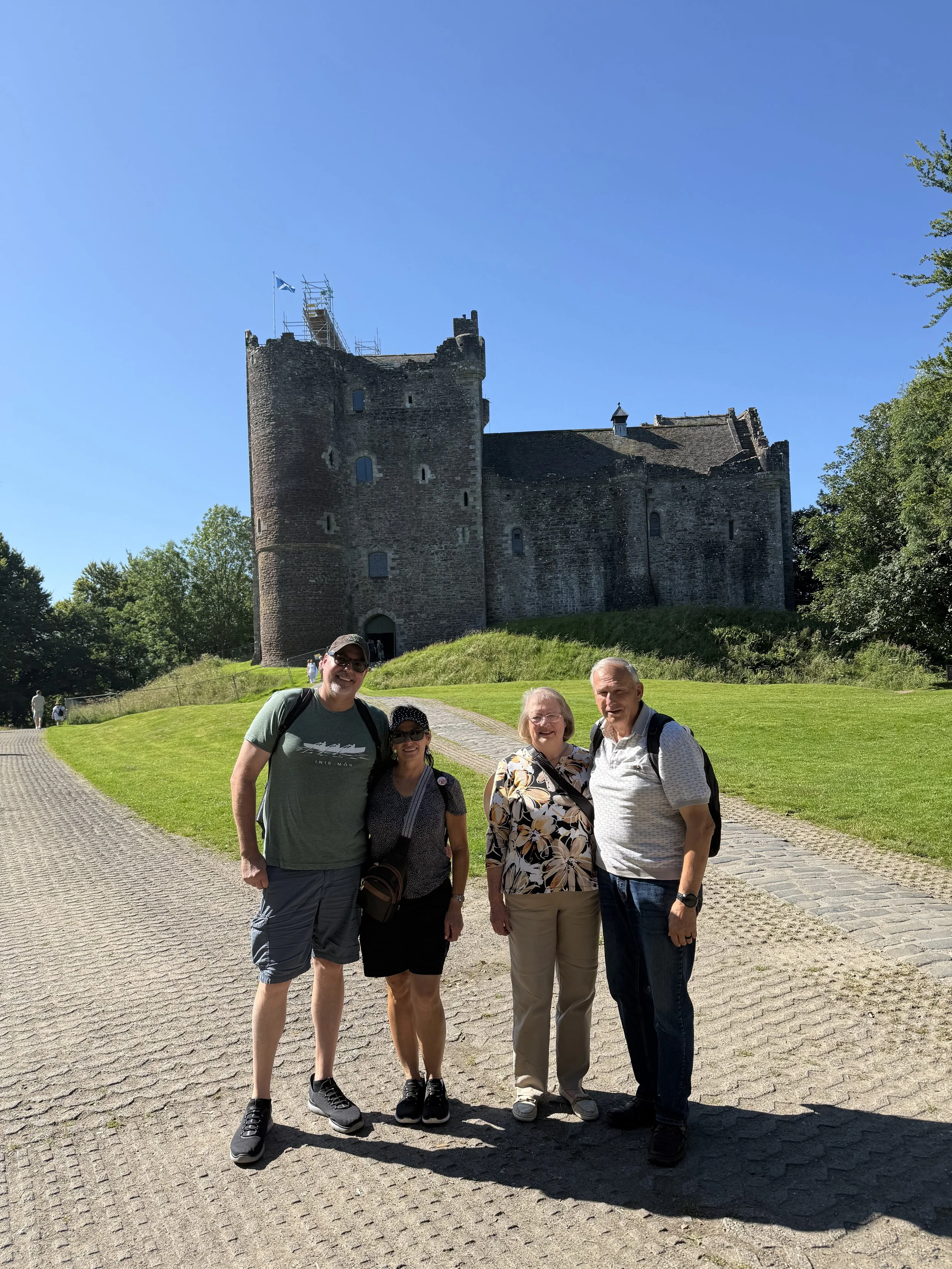 Tour guests together on the path in front of a Scottish castle