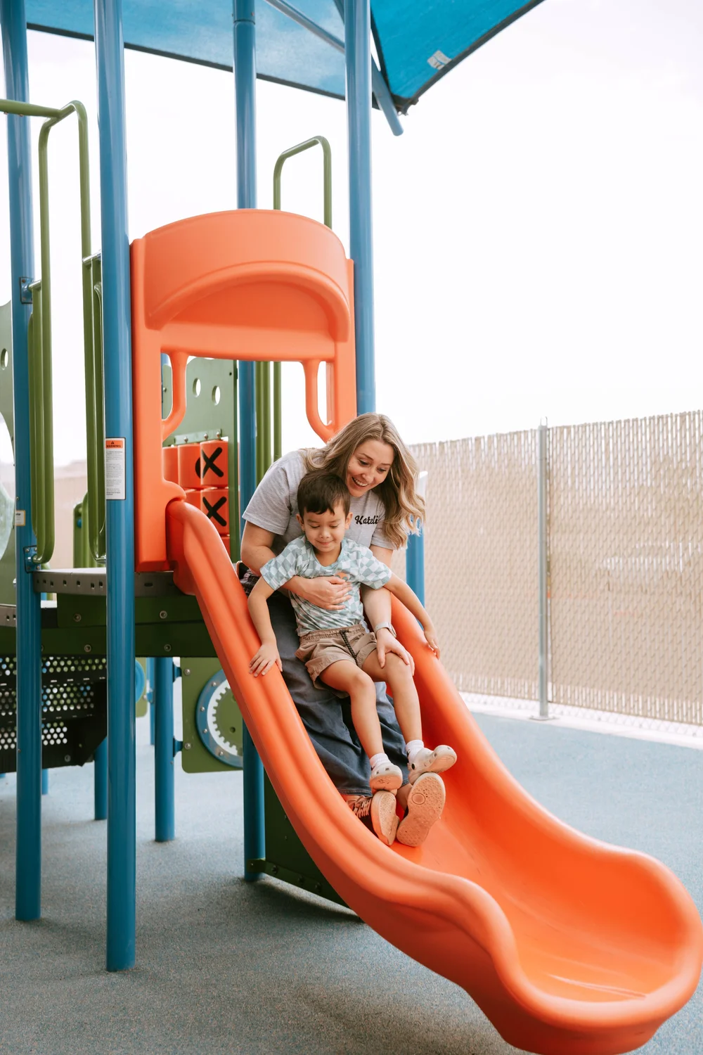A staff member supporting a child during playground time