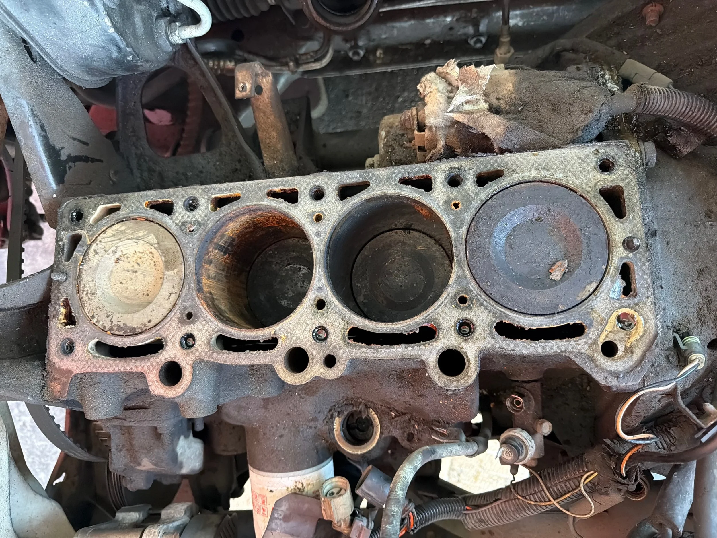 The engine block with the head removed, showing the cylinder bores and the old head gasket surface