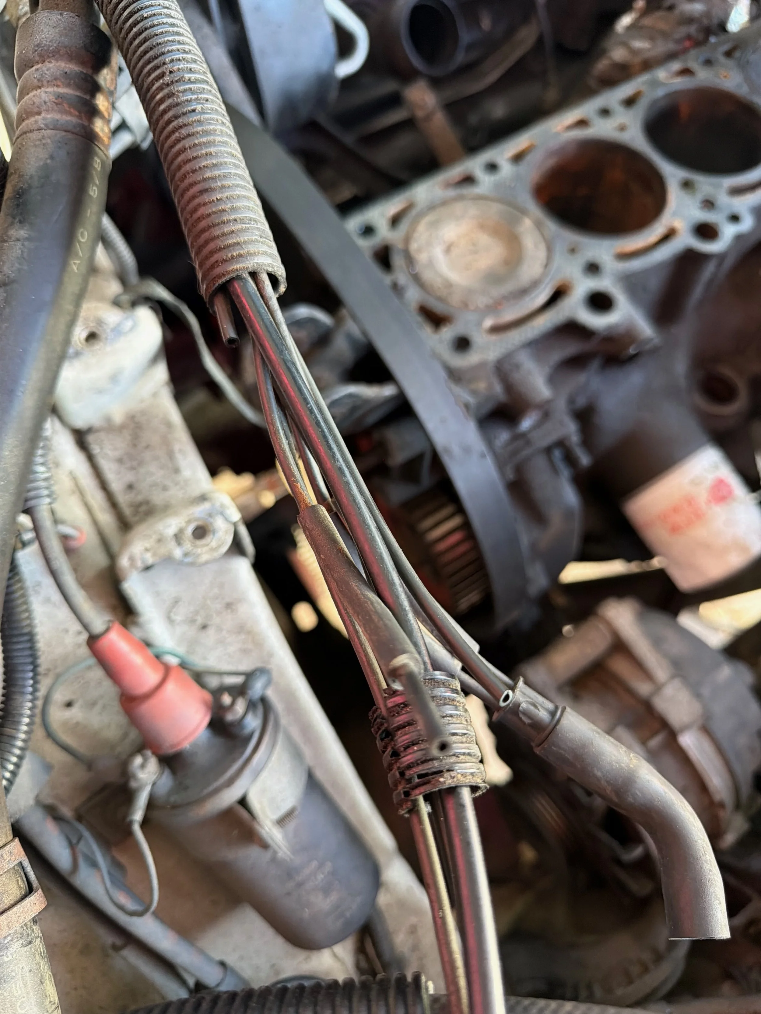 Close-up of wiring harness inside the engine bay with the block exposed in the background
