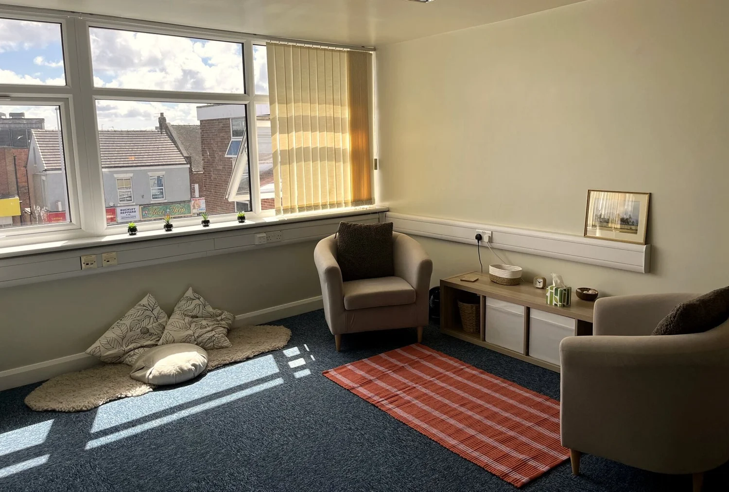 Sunny counselling room in Bispham, Blackpool, with armchairs and floor cushions