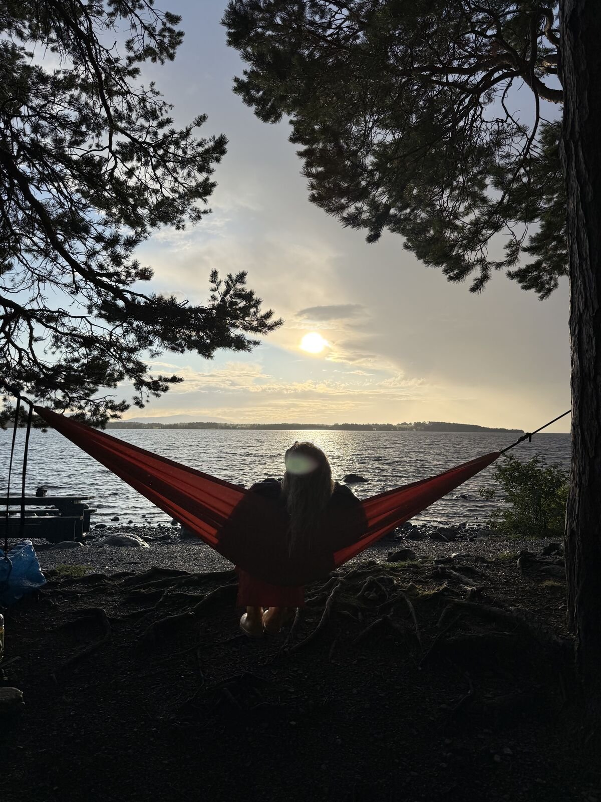 Resting in a hammock by the lake at sunset
