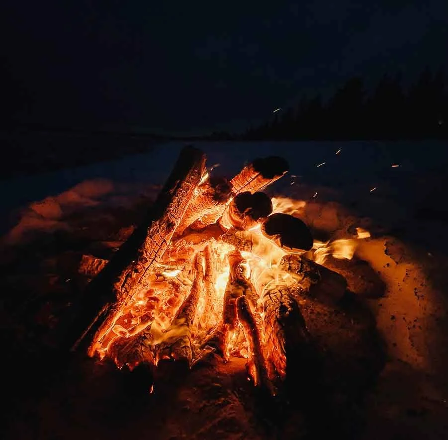 A log fire burning on the snow at night