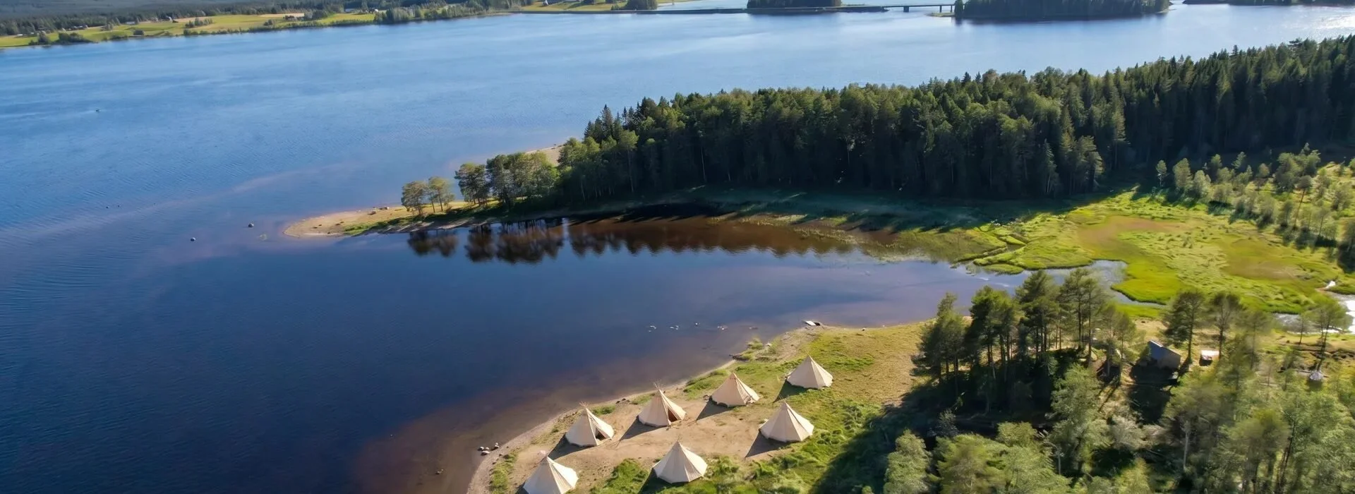 The camp on a peninsula by the lake, with the Bydalen mountains behind