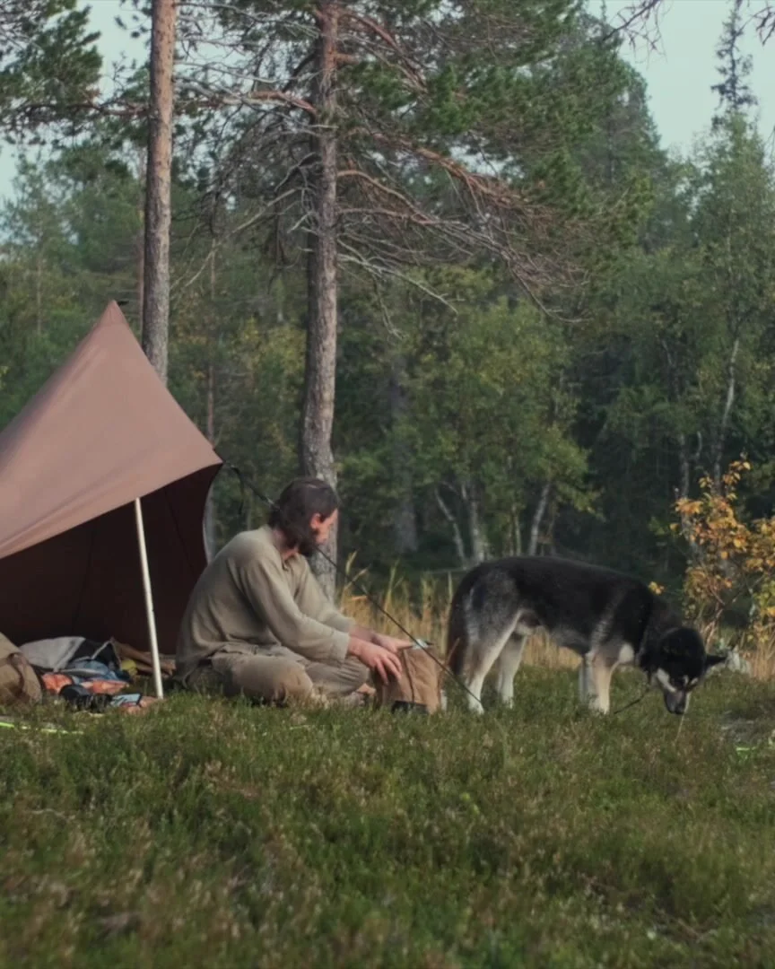 George and his dog at a tarp tent in the forest