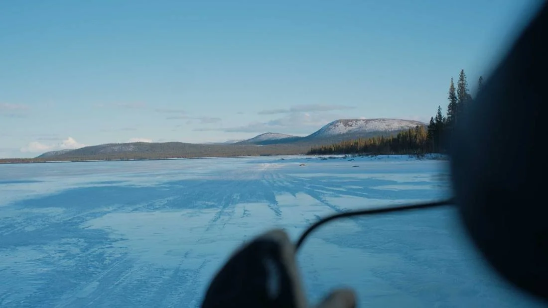 Snowmobile tracks across a frozen lake