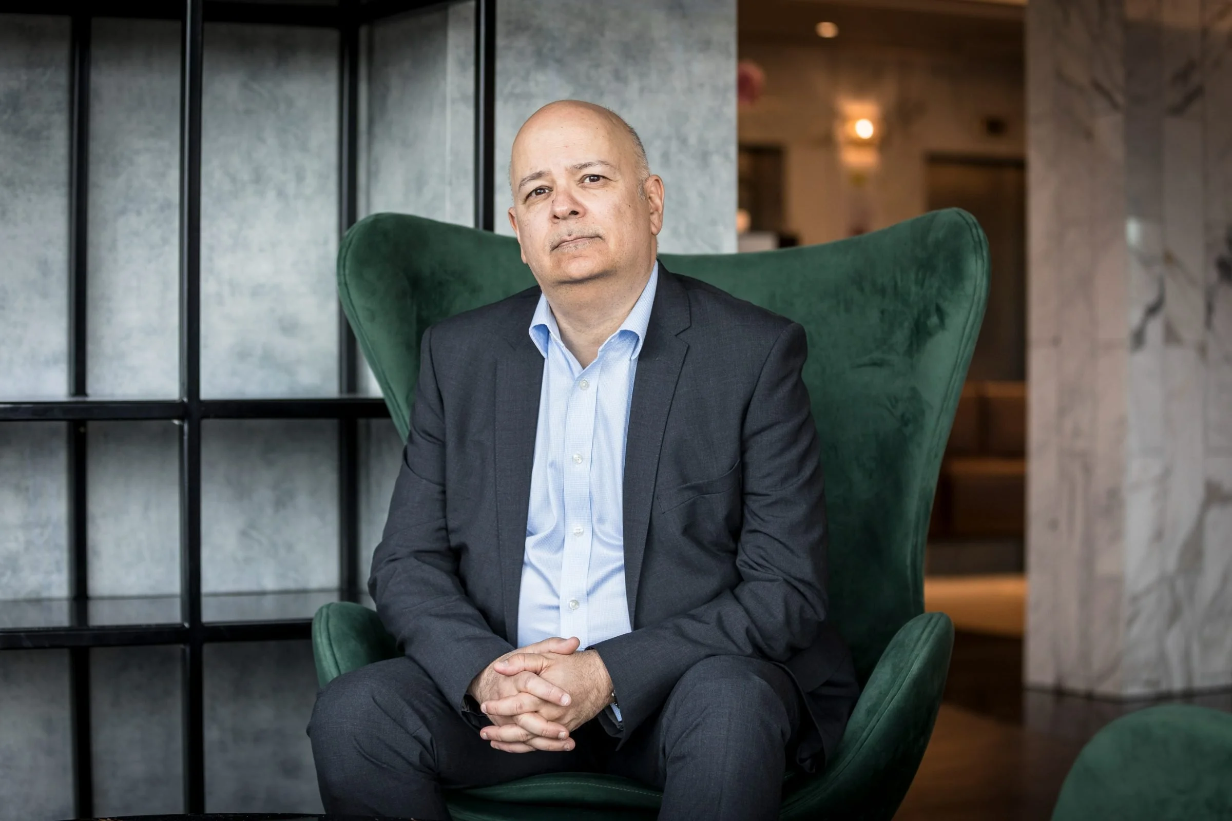 Olivier Guitta geopolitical risk and security strategist and keynote speaker sitting on a lounge chair with arms in lap