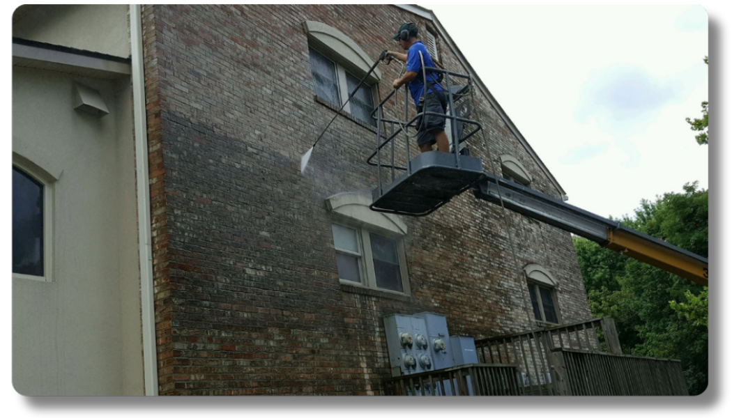 Hot Shot Pressure Washing technician on a boom lift cleaning a multi-story apartment complex in the Roanoke Valley