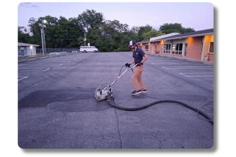 Hot Shot Pressure Washing technician using a surface cleaner on a commercial parking lot in the Roanoke Valley