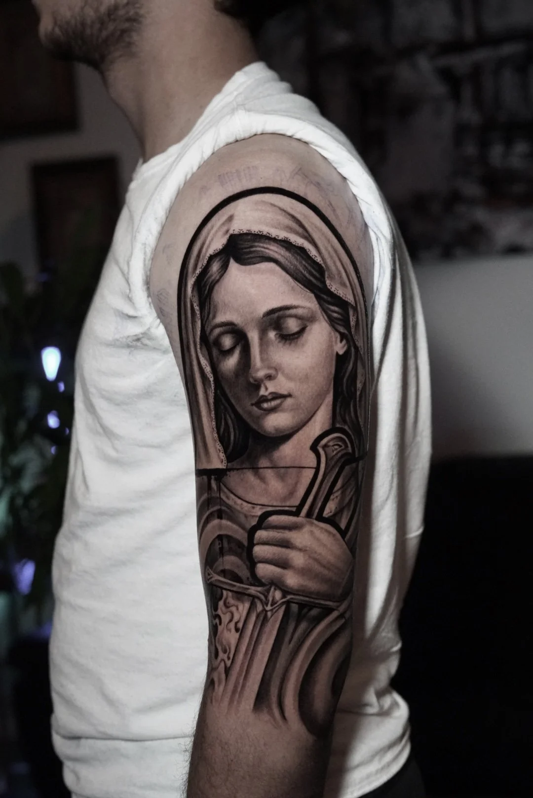 Black-and-gray Virgin Mary upper-arm tattoo at Black Craft Tattoo Collective in Charlotte, NC.