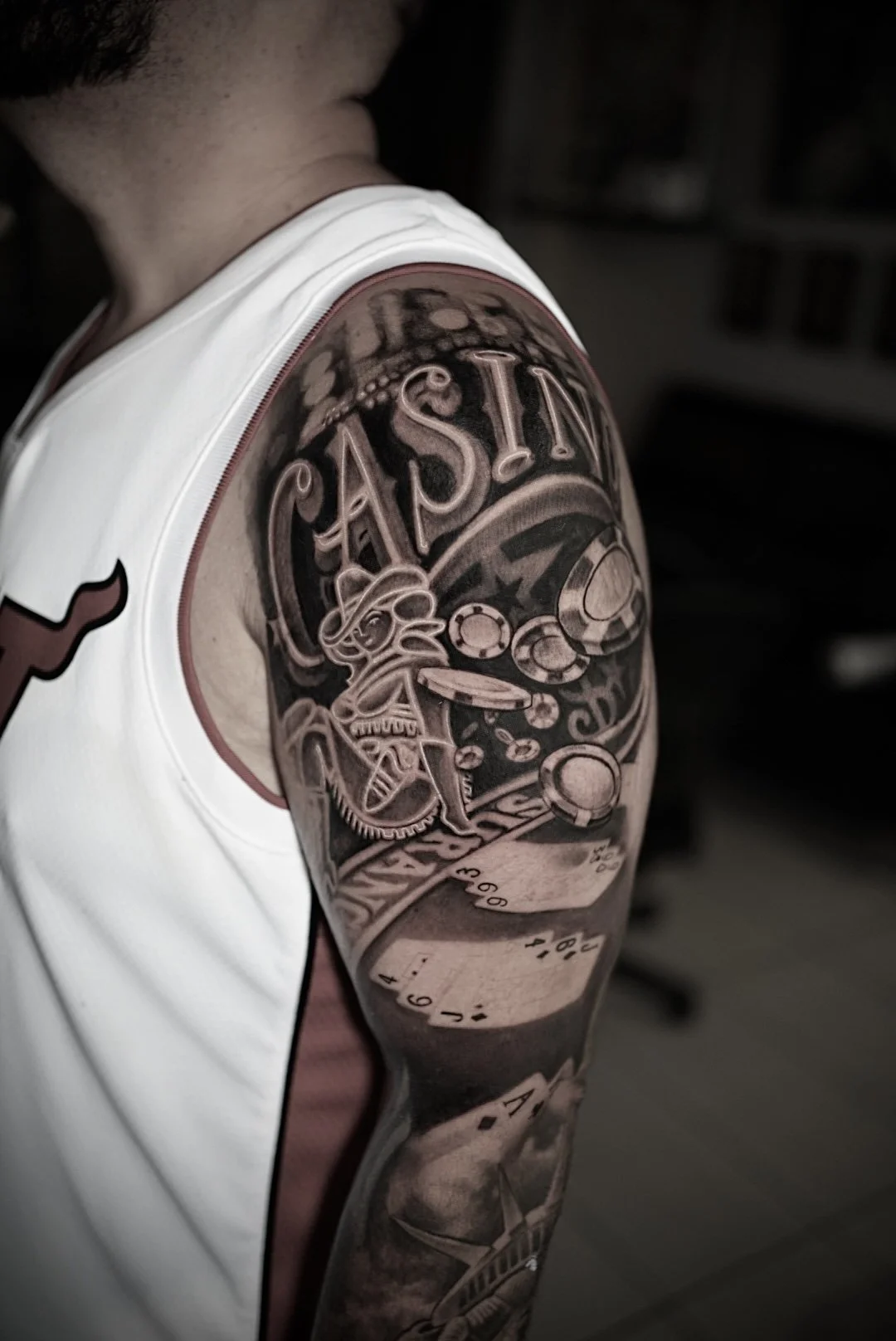 Black-and-gray casino gambling upper-arm tattoo at Black Craft Tattoo Collective in Charlotte, NC.