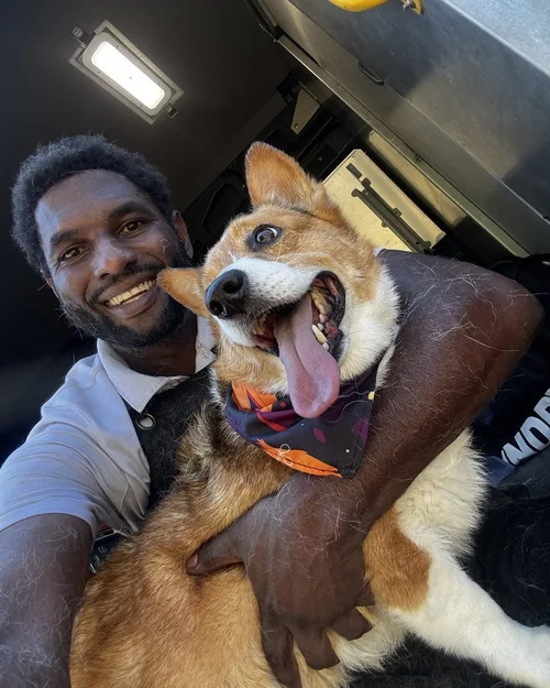 A corgi getting a hug from our Lead Groomer after a Spa Day