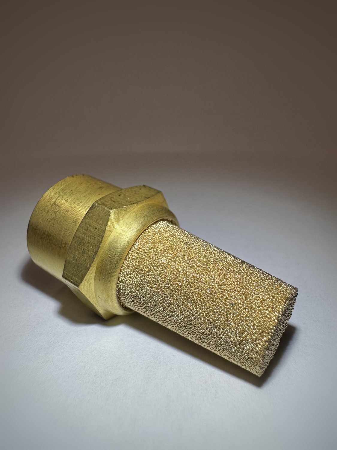 Close-up of the 20-micron sintered bronze diffuser element showing its porous surface.