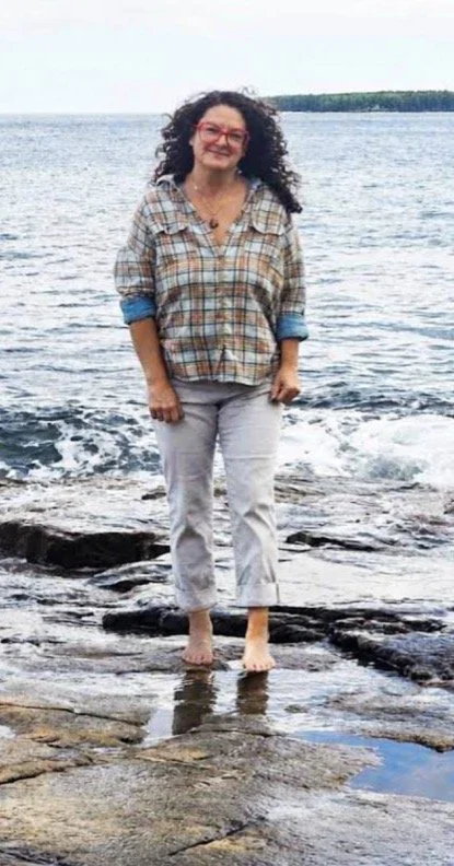 Amanda Gautreaux standing on the rocky Maine coast