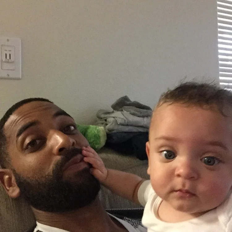 A baby reaching for his father’s cheek