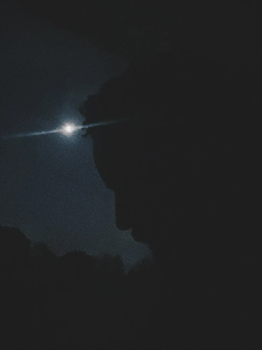 Rashad Houston in silhouette beneath the moon.
