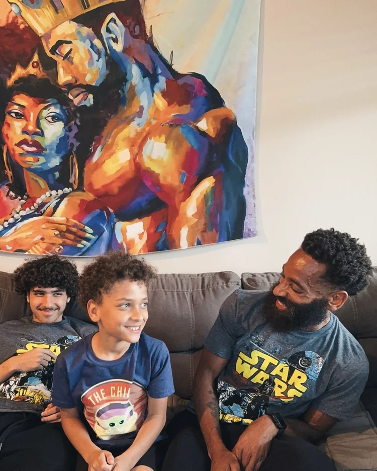 Rashad talking with his sons on the couch.