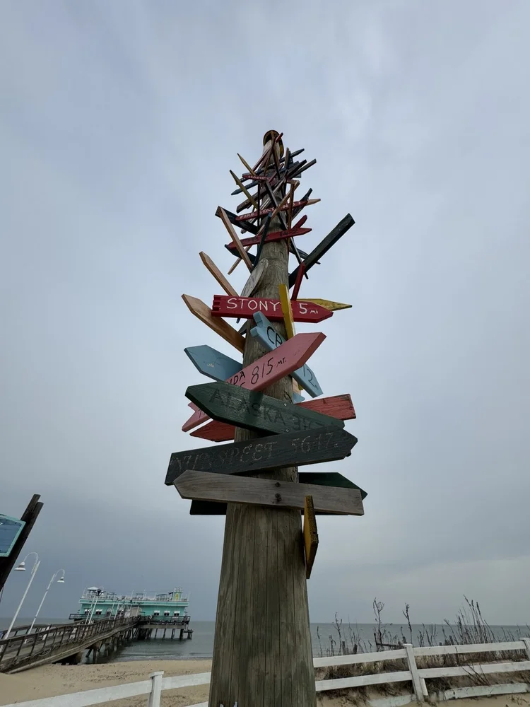 A sculptural signpost beside the coast.