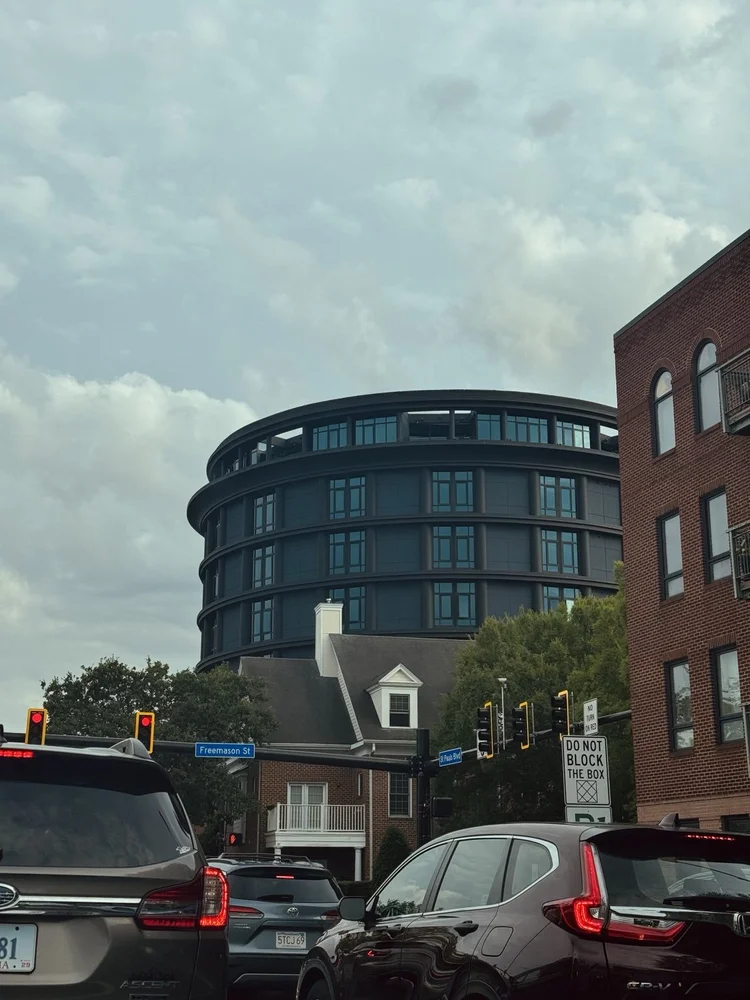 A rounded modern building above a city street.
