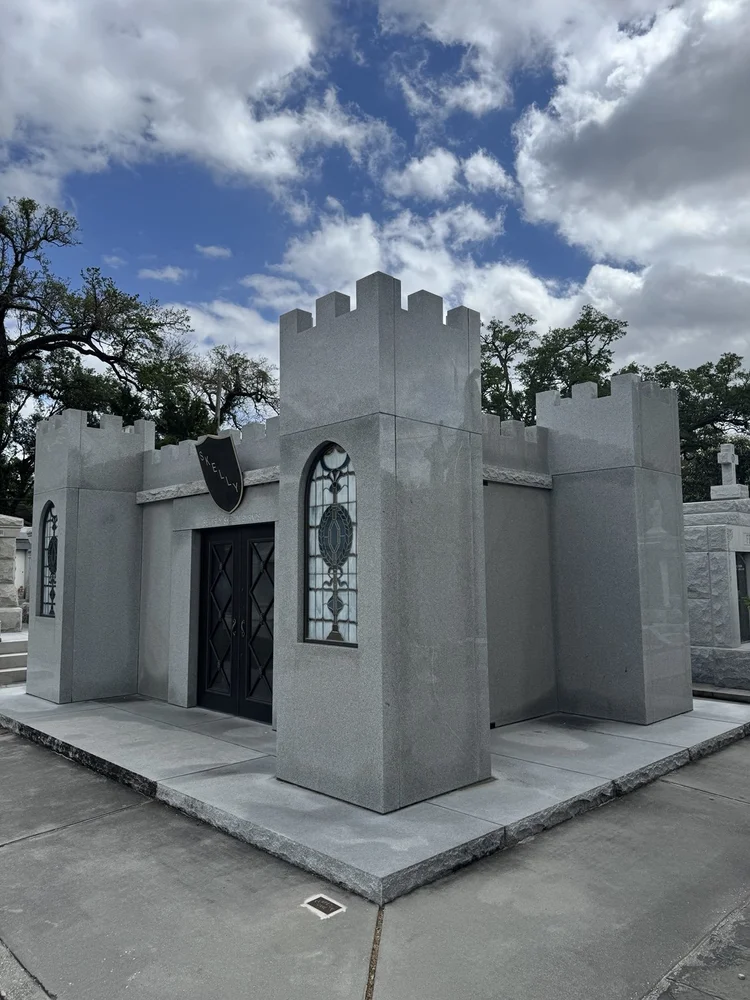 A white stone mausoleum beneath a blue sky.
