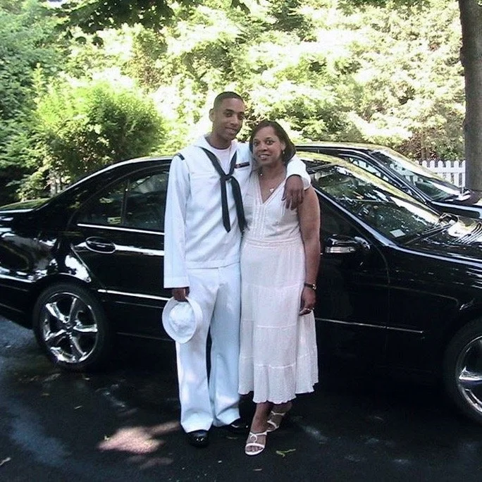 Rashad in Navy uniform beside a woman.