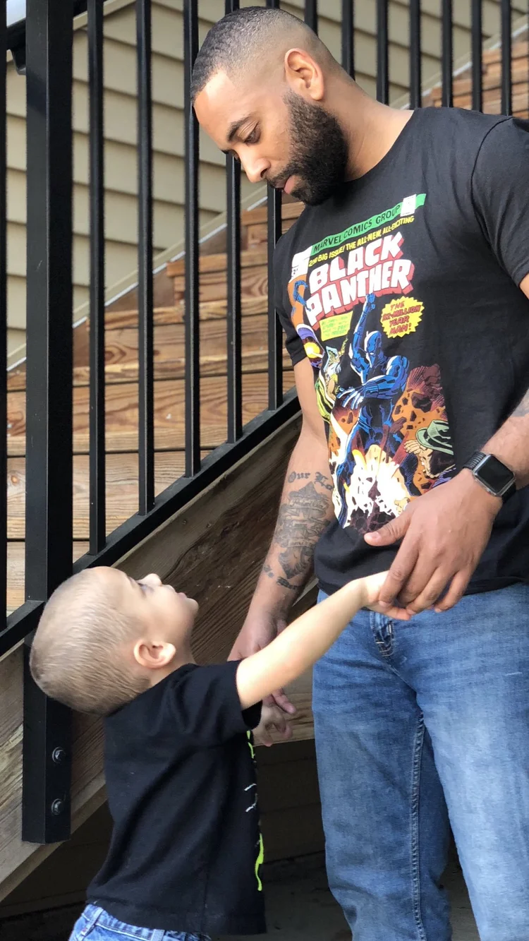 Father and young son holding hands beside outdoor steps