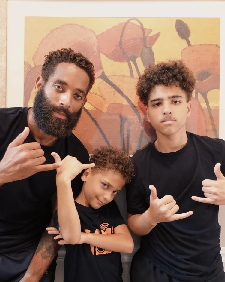 Rashad and both sons making shaka gestures