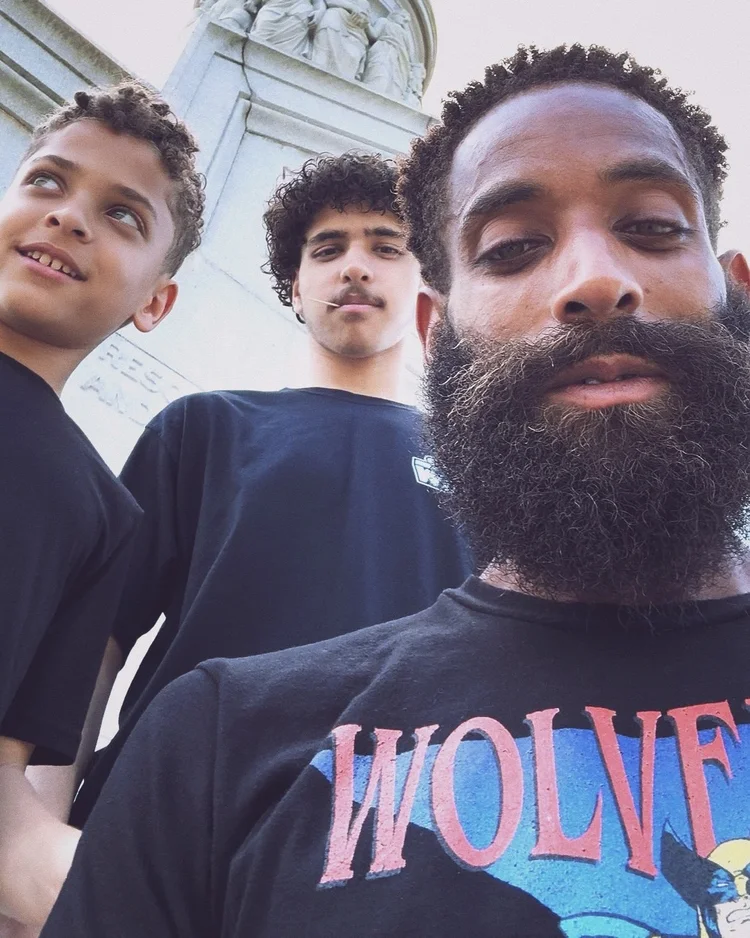 Aidan, Omari, and Rashad together in an outdoor family selfie.
