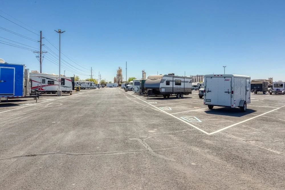 Uncovered RV storage spaces on open lot at Carefree Covered RV Storage in Chandler, AZ