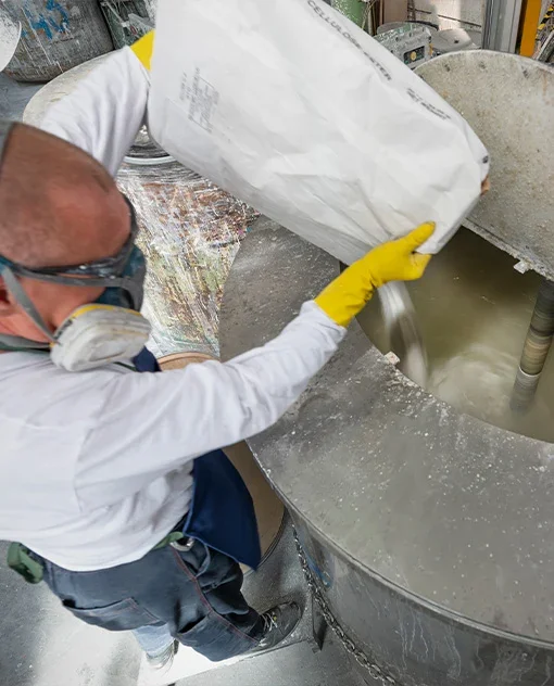Verinlegno production operator adding raw material to a coating mixing vessel